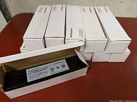 Stack of twelve white retail boxes with one LED driver exposed