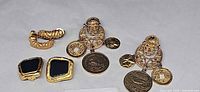 All three earring pairs laid out: coin dangles, black cabochon squares, textured hoops