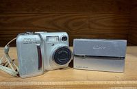 Front view of Nikon Coolpix 775 beside Sony Cyber-shot DSC-T9 on shelf