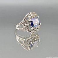 Front view of ring showing mystic topaz, halo of accent stones, and filigree design