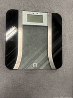 Top view of scale showing glass platform, black frame, silver trim, LCD screen and WW logo