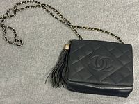 Front and top view showing quilted leather, embossed CC logo, tassel, and chain strap