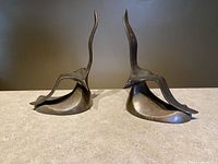 Pair of brass abstract seagull sculptures side view showing patina and form