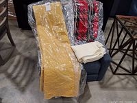 All three textiles on chair: yellow quilt, plaid throw, white throw