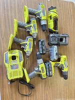 Group shot of five Ryobi cordless tools, two chargers and batteries on tabletop