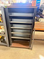 Front view of bookcase showing five adjustable metal shelves within engineered wood frame