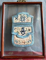 Front view of framed embroidered pouch