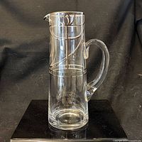 Front view showing silver-plated rim, etched design, handle, overall form