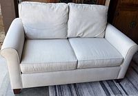 Front view of beige Pottery Barn loveseat showing overall style and upholstery