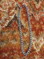 Full view of stainless steel curb necklace laid flat