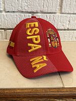 Front three-quarter view showing embroidered coat of arms and “ESPAÑA” text