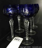 Front view of all six cobalt blue Traube hock glasses showing pattern and faceted stems