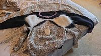 All three sweaters layered to show colors, trims, faux-fur accents