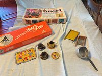Overview of all items: cutter kit box, kite kit box, tinplate toys, saucepan