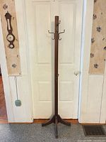 Full view of wooden coat rack against door