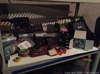 Shelf displaying assorted fly fishing gear including packaged flies, fishing line, and tackle boxes with various fishing items