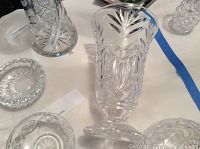Close view of several clear crystal bowls and vases showing cut patterns and starbursts