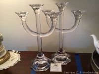 Pair of Villeroy & Bosch lead crystal 3-arm candelabras shown on a surface with a lamp and other items nearby.