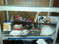 Shelf with Le Creuset dishes, cookie molds, wire rack, and mandoline slicer box