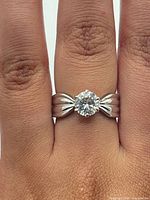 Ring on hand showing stone and fluted shoulders