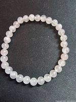 Full view of rose quartz beaded stretch bracelet laid flat