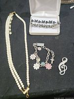 All four jewelry pieces displayed: necklace, two bracelets, brooch