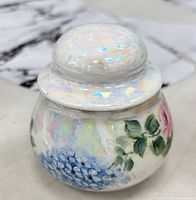 Closed jar showing floral design and iridescent lid