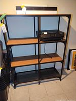 Front view of entire black metal frame bookcase with wooden shelves and mesh bottom