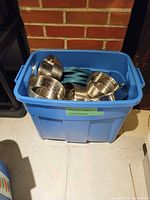 Blue tote holding multiple stainless steel bowls and teal lids