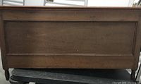 Front view of solid wood blanket chest showing paneled design and surface wear