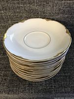 Stack of saucers showing gold scalloped rims