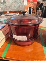 Stacked cranberry glass roaster with lid atop shallow casserole dish