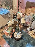Full view of lamp in pot with white stones and separate faux flower pot