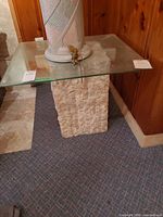 Full view of glass top end table showing glass surface and stone base