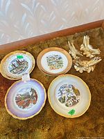 Overall lot: four decorative Kleiber porcelain plates and three gold-tone ceramic birds