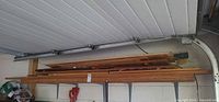 Stacked plywood sheets and lumber on wall shelf