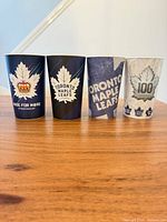 All four souvenir cups side by side to show variety and overall condition