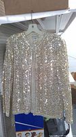Front view of gold sequin jacket on hanger