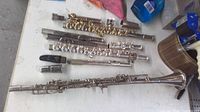 Overview of clarinet, mouthpiece and multiple flute sections on table