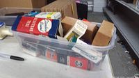 Plastic tote filled with boxed and loose vacuum tubes