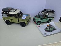 Both assembled Defender vehicles and manual on table