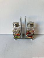 Front view of both shakers in chrome caddy