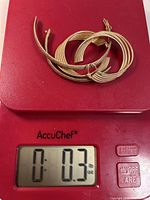Bracelet and earrings on scale showing 0.3 oz