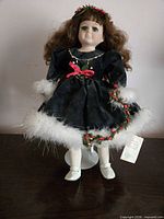 Front view of porcelain doll in green velvet dress on stand