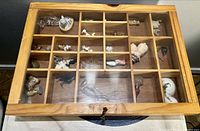 Closed view of wood display case showing grid compartments and figurines