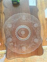 Top view of entire clear glass platter showing floral etching and scalloped rim