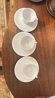 Top view of three cup-saucer sets displaying ribbed pattern and overall condition