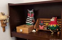 Shelf with desk organizer, tall cat figurine, rounded cat on bench, miniature items