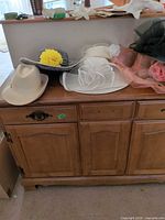 Multiple decorative hats on cabinet top