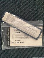 Slide rule inside blue case with instruction booklet in plastic bag